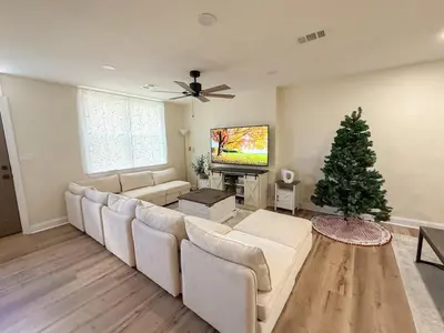 a living room with a couch and a christmas tree at South Philly Retreat with Movie Nights and Backyard BBQ in Philadelphia