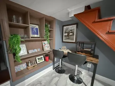 a bar with two chairs and a table in a room at South Philly Retreat with Movie Nights and Backyard BBQ in Philadelphia