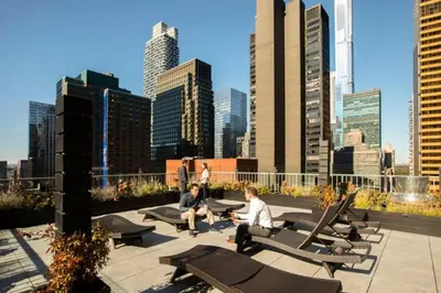 two men sitting on benches in front of a city skyline at Executive Plaza in New York