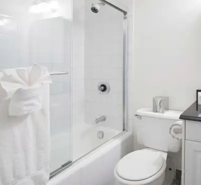 a white bathroom with a toilet and a shower at Executive Plaza in New York