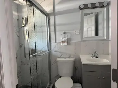 a bathroom with a shower and a toilet and a sink at Lovely 2Bed in Newark in Newark