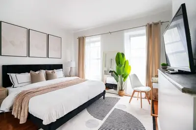 a bedroom with a large bed and a flat screen tv at Prime location 1BR Newly Furnished in New York