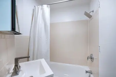 a white bathroom with a sink and a shower at Prime location 1BR Newly Furnished in New York