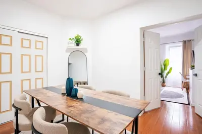 a dining room with a wooden table and chairs at Prime location 1BR Newly Furnished in New York