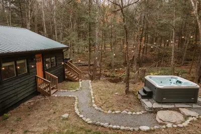 a tub sitting in the yard next to a cabin at Creekside Modern Cabin Sauna Hot Tub Niksen Den in Callicoon