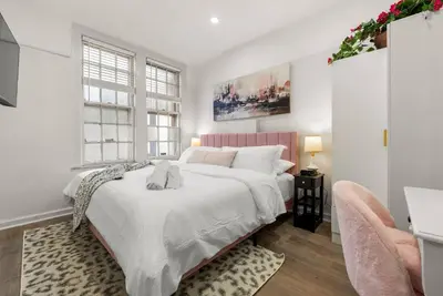 a white bedroom with a large bed and a window at FIFA26|Based Btwn MetLife & Manhattan|Parking in Bayonne