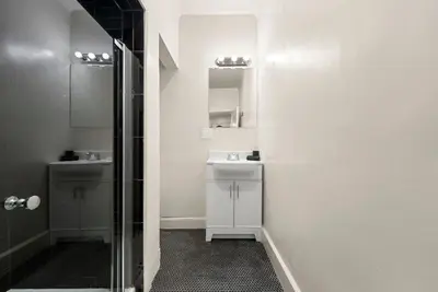 a white bathroom with a sink and a shower at FIFA26|Based Btwn MetLife & Manhattan|Parking in Bayonne