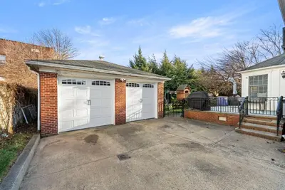 a garage with two white garage doors on a house at FIFA26|Based Btwn MetLife & Manhattan|Parking in Bayonne