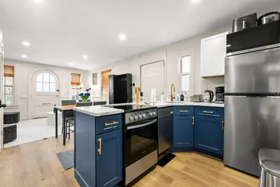 a kitchen with blue cabinets and stainless steel appliances at FIFA26|Based Btwn MetLife & Manhattan|Parking in Bayonne