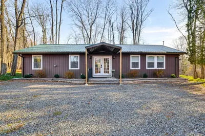 a house with a gravel driveway in front of it at Pet-Friendly Group Getaway 12 Mi to Camelback Mtn! in Cresco