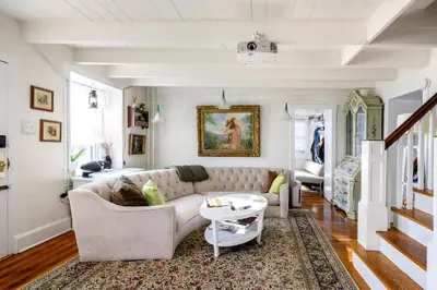 a living room with a couch and a table at Charming Historic Riverfront Home with Garden Views near Lambertville, New Jersey in Titusville