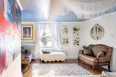 a living room with a couch and a window at Charming Historic Riverfront Home with Garden Views near Lambertville, New Jersey in Titusville