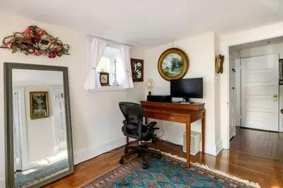a mirror in a room with a desk and a computer at Charming Historic Riverfront Home with Garden Views near Lambertville, New Jersey in Titusville