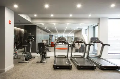 a gym with treadmills and ellipticals in a room at Central Chelsea 1BR w Gym Doorman NYC-20 in New York