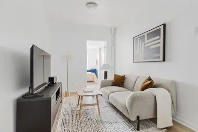 a living room with a couch and a tv at Blueground Alphabet City washer nr Tompkins Square Park NYC-2160 in New York