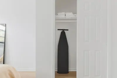 a bedroom with a black tie hanging on a door at Blueground Alphabet City washer nr Tompkins Square Park NYC-2160 in New York