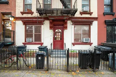 a red door on a house with a fence at Blueground Alphabet City washer nr Tompkins Square Park NYC-2160 in New York