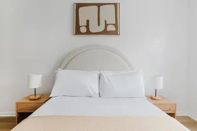 a bedroom with a white bed with two lamps at Blueground Alphabet City washer nr Tompkins Square Park NYC-2160 in New York