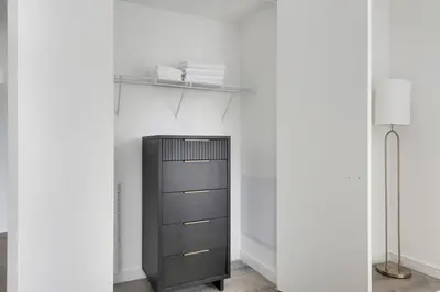 a black cabinet in a white room with a shelf at Blueground Midtown South rooftop nr Bryant Park NYC-2031 in New York