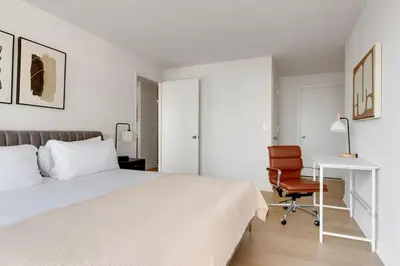 a bedroom with a bed and a desk and a chair at Blueground Upper West Side fitness nr Central Park NYC-1993 in New York