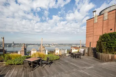 a patio with tables and chairs on top of a building at Blueground Upper West Side fitness nr Central Park NYC-1993 in New York