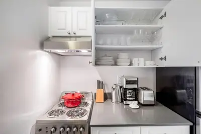 a kitchen with a stove top oven next to a microwave at Chelsea 1BR w Water views Doorman NYC-210 in New York