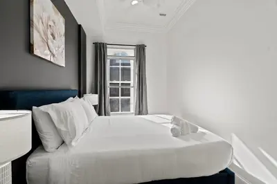 a white bed in a room with a window at Apartmint at 113 Chestnut - Philadelphia in Philadelphia