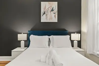 a bedroom with a large white bed with two lamps at Apartmint at 113 Chestnut - Philadelphia in Philadelphia