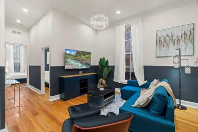 a living room with a blue couch and chairs at Apartmint at 113 Chestnut - Philadelphia in Philadelphia