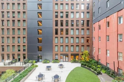 a courtyard with tables and chairs in front of buildings at Blueground Chelsea rooftop pool nr The Vessel NYC-2147 in New York