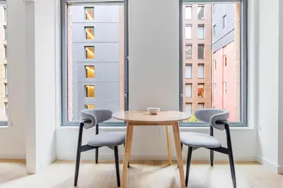 a table and two chairs in a room with a window at Blueground Chelsea rooftop pool nr The Vessel NYC-2147 in New York