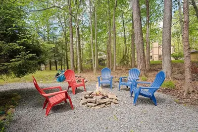 a group of four chairs around a fire pit at Lake Naomi Retreat Family Fun & Games in Pocono Pines
