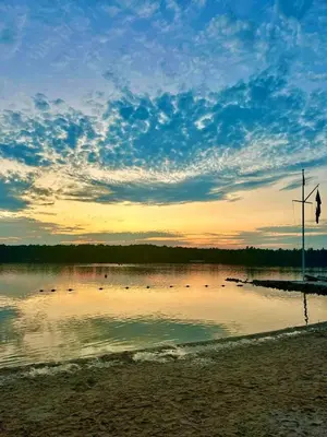a group of ducks swimming in a lake at sunset at Lake Naomi Retreat Family Fun & Games in Pocono Pines