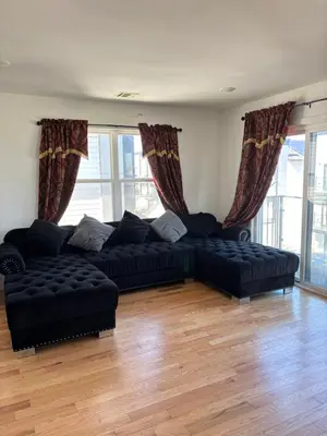 a living room with black couches and windows at 730 Seaport Drive in Elizabeth