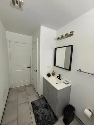 a white bathroom with a sink and a mirror at 730 Seaport Drive in Elizabeth