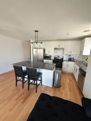 a kitchen with white cabinets and a table and chairs at 730 Seaport Drive in Elizabeth