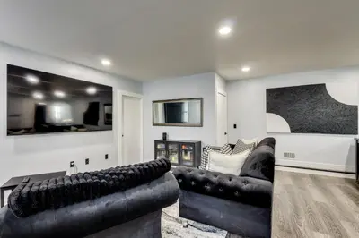 a living room with two leather couches and a fireplace at 4 Mi to MetLife Stadium Modern Retreat! in Wallington