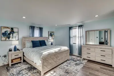 a bedroom with a large bed and a mirror at 4 Mi to MetLife Stadium Modern Retreat! in Wallington