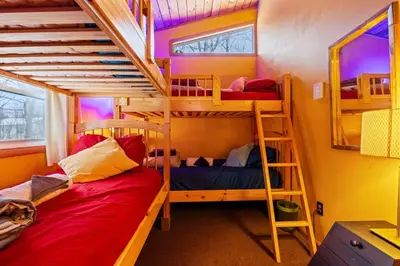 two bunk beds in a room with two beds at Hot Tub + Fire Pit • Game Room • Community Pool in Tobyhanna