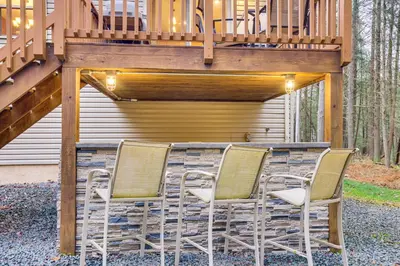 a group of chairs sitting under a deck at Fire Pit, Games and Outdoor Fun! Poconos Retreat in Blakeslee