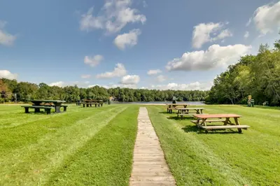a row of picnic tables in a grass field at Fire Pit, Games and Outdoor Fun! Poconos Retreat in Blakeslee