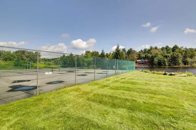 a chain link fence next to a parking lot at Fire Pit, Games and Outdoor Fun! Poconos Retreat in Blakeslee