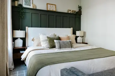 a bedroom with a large bed with a green headboard at The Citizen Suite - Downtown in Lancaster