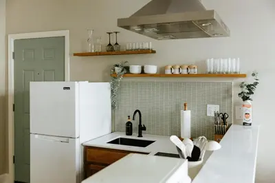 a kitchen with a white refrigerator and a sink at The Citizen Suite - Downtown in Lancaster