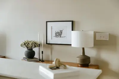 a lamp on a table with a picture on the wall at The Citizen Suite - Downtown in Lancaster