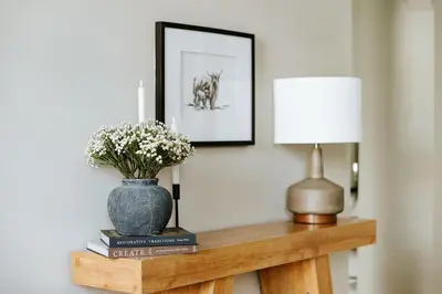 a table with a vase of flowers and a lamp at The Citizen Suite - Downtown in Lancaster