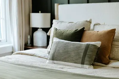 a bedroom with a bed with pillows and a lamp at The Citizen Suite - Downtown in Lancaster