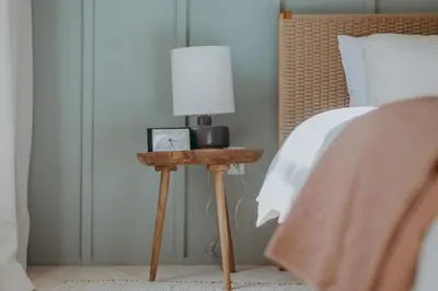 a bed with a table with a lamp on it at Maisonette on Duke - Downtown in Lancaster