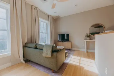 a living room with a couch and a tv at Maisonette on Duke - Downtown in Lancaster