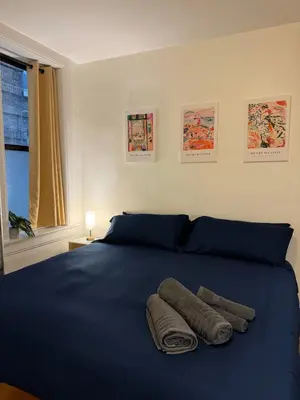 a bedroom with a blue bed with two towels on it at The Broadway Escape - Private Room in Times Square in New York